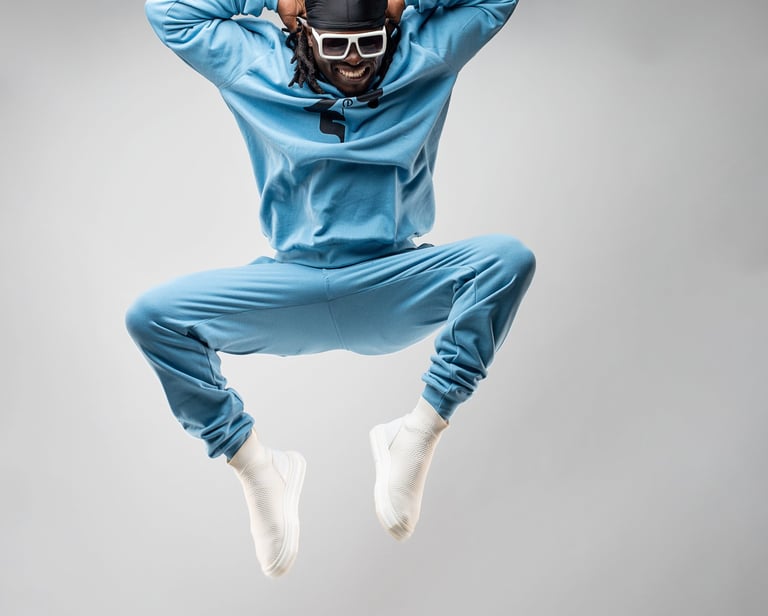 Dancer Chiluba TheOne, founder of TheOne Studios jumping in a blue sweat shirt and pants