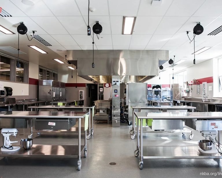 Large culinary teaching space with mobile stainless steel work tables and industrial prep stations from the About SSB team.
