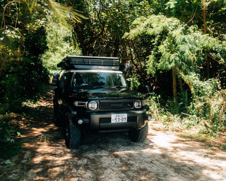 Toyota FJ Cruiser parked on a sandy trail surrounded by lush greenery in Okinawa. | Evertrail Okinawa