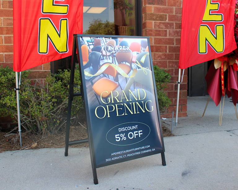 a sign board with a grand opening sign
