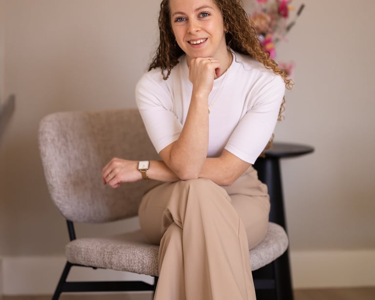 a woman (the owner) sitting in a chair with a flower in the background