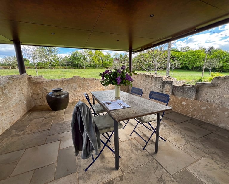 Une table avec des chaises sur une terrasse accueillante en Périgord