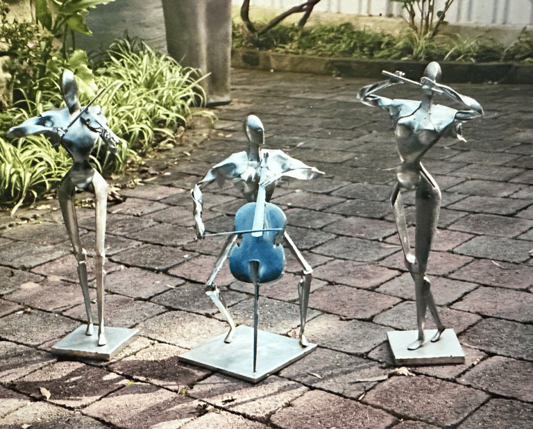 three zinc coated steel sculptures of musicians playing instruments