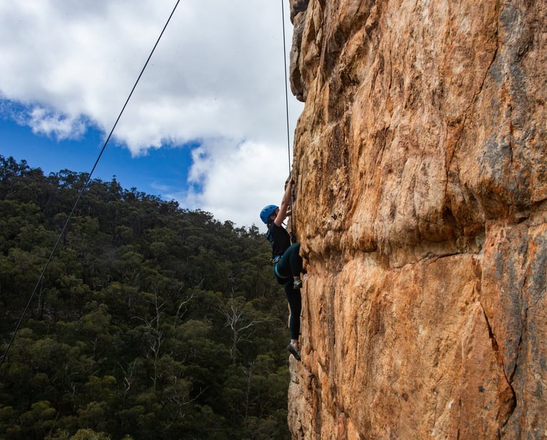 Climbers scaling natural rock faces during a half day rock climbing session at Morialta