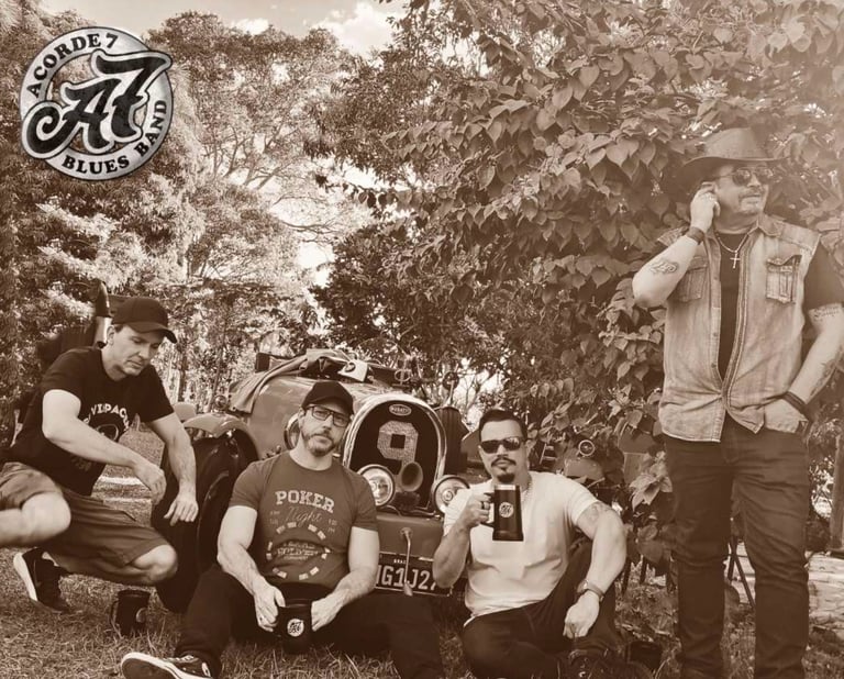 Acorde 7 Blues Band members posing with a vintage classic car in a sepia-toned outdoor portrait.