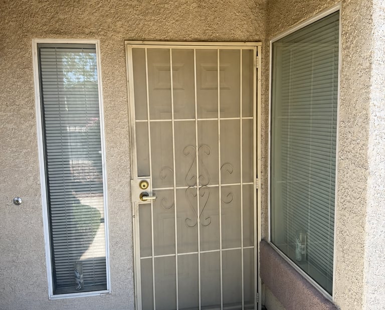 Front door of condo without solar screens on its two front windows.