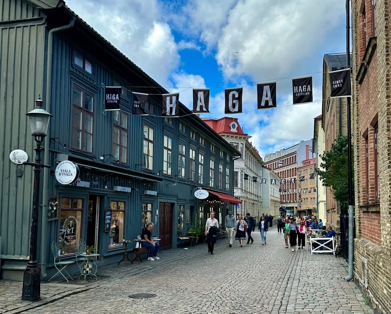 The neighberhood Haga in Gothenburg with people walking down a cobblestonestreet