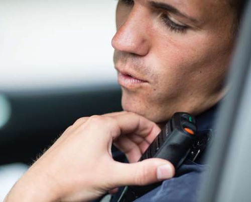 Person in vehicle using their microphone/speaker connected to their portable radio