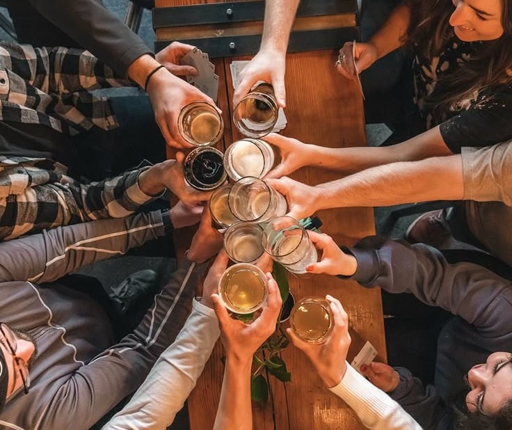 a group of people at the Riga Pub Crawl standing around a table with beer glasses