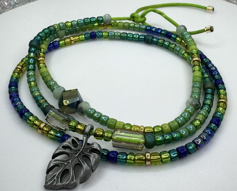Tiny iridescent glass beads in vibrant shades of green blue & gold in a triple wrap bracelet design