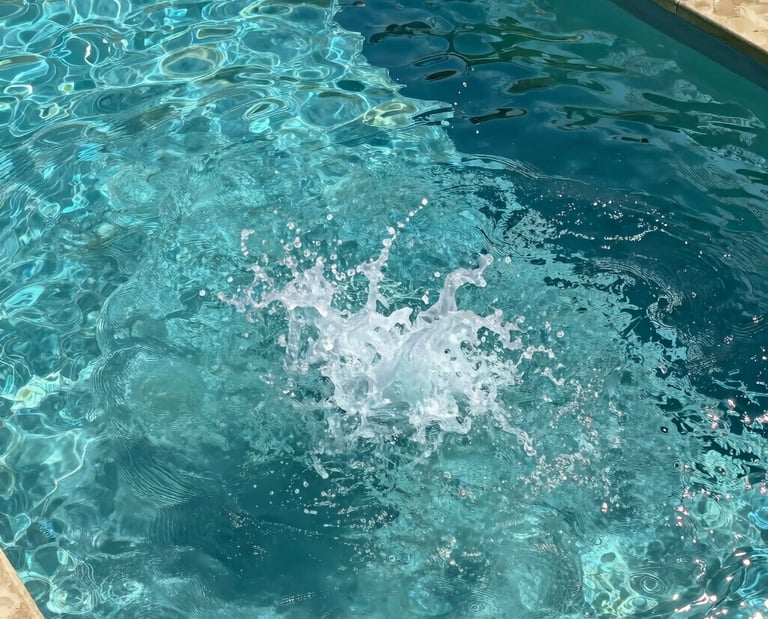 A large water splash in a clear turquoise backyard swimming pool with sunlight reflecting on the surface.