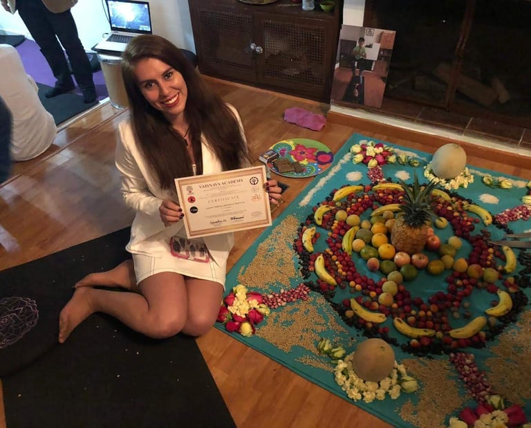 mujer sentada al lado de un mandala de frutas