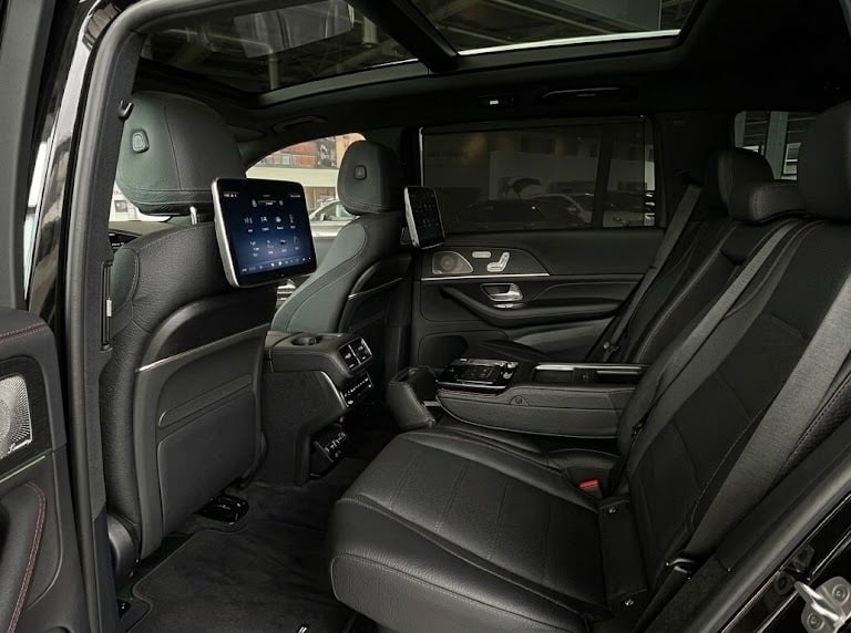 Luxury SUV interior with black leather seats, rear entertainment screens, and a panoramic sunroof.