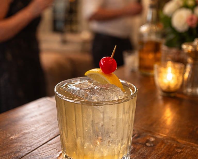 Private party at clients house enjoying whisky sour cocktails big ice lemon and cherry garnish