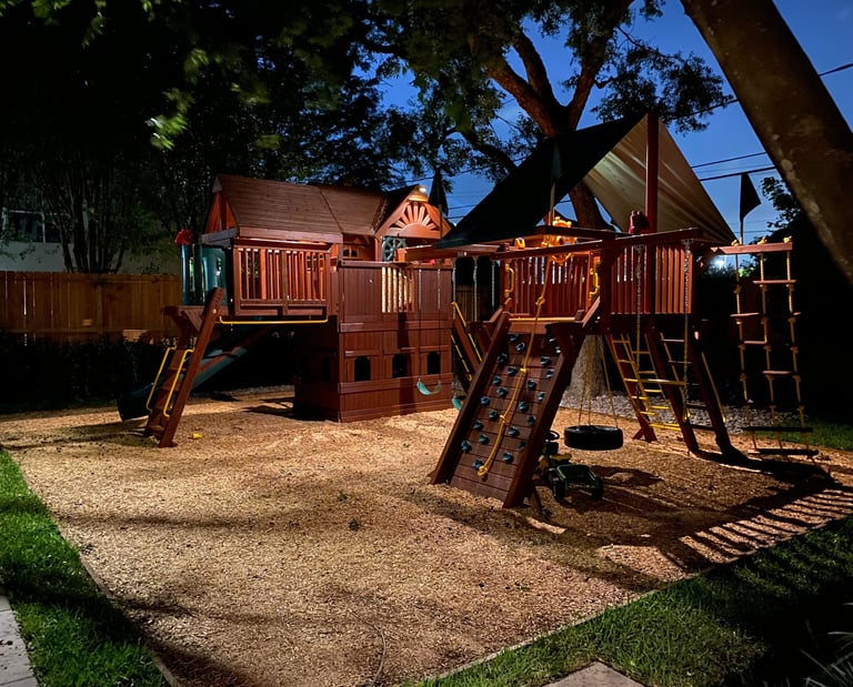 landscape lights installed on a swing set for a kids playground