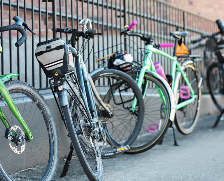 A bunch of bikes leaning up against a fence