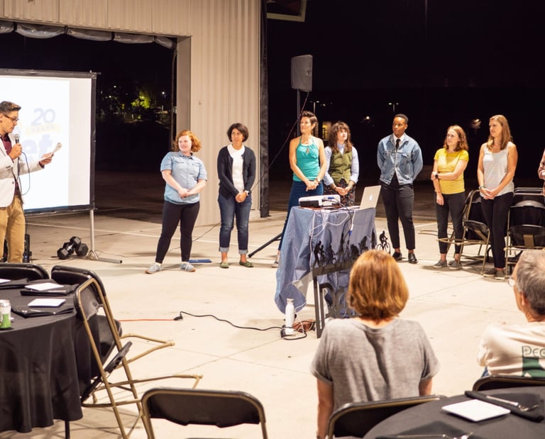 Staff members lined up in front of an audience, giving a presentation