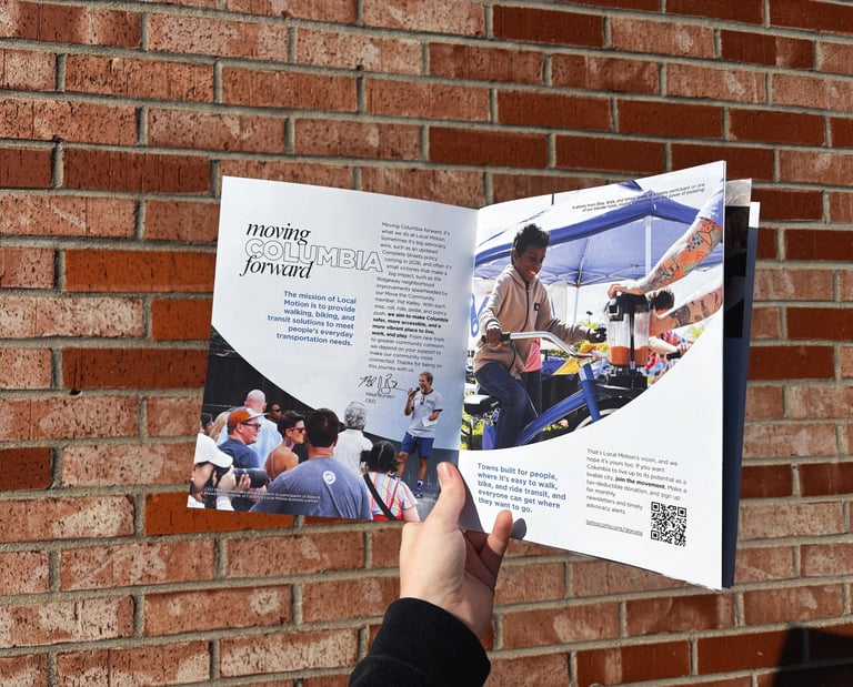 A hand holding open the 2025 Annual Report Booklet