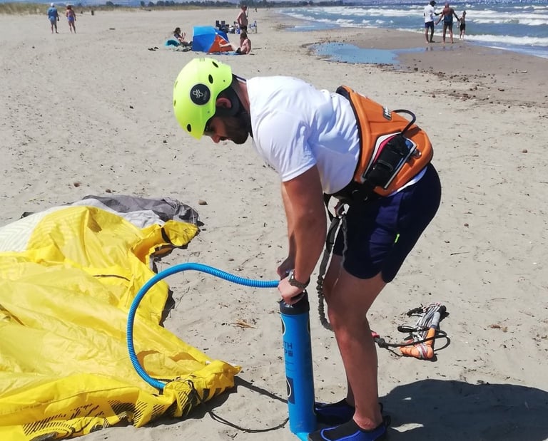 Allievo principiante intento a gonfiare una vela di kitesurf