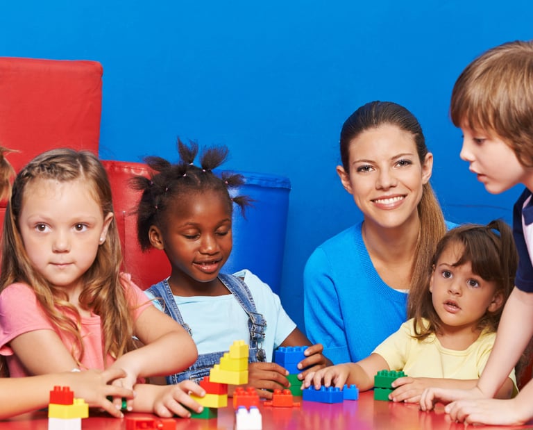 a woman and children playing with blocks on a table