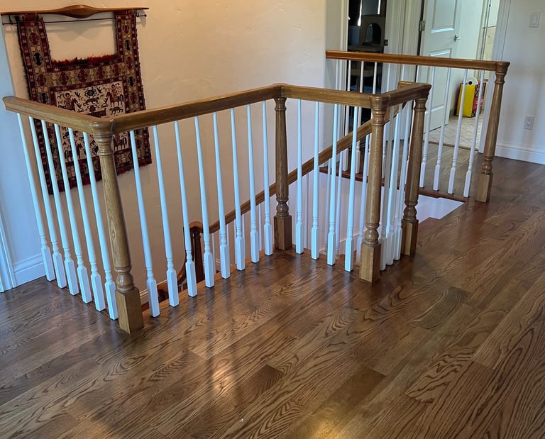 a staircase way with a hardwood floor and a wooden railing