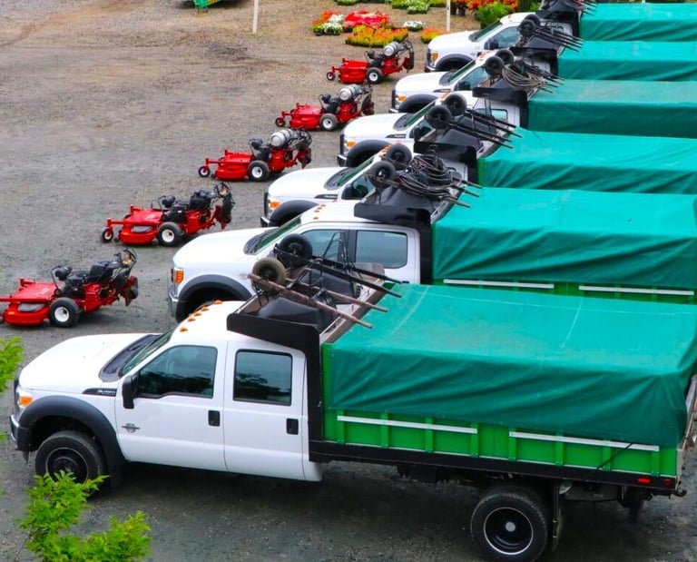 fleet of landscaping trucks with equipment