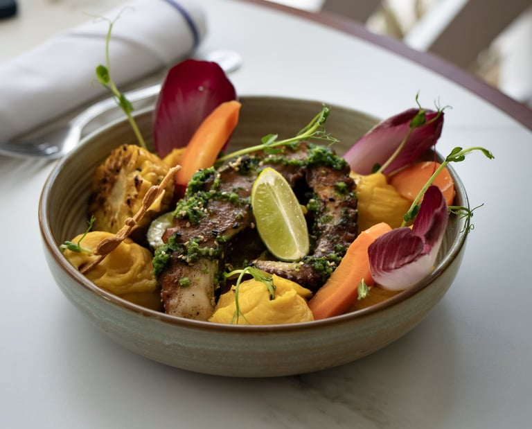 Une assiette de tentacule de poulpe braisé et petits légumes