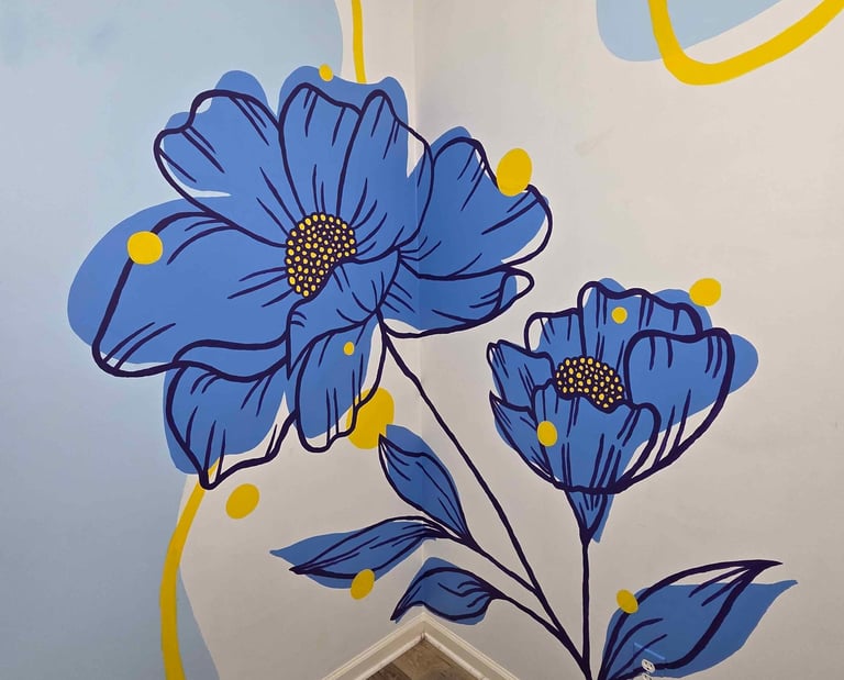 Hand-painted blue floral mural with yellow abstract accents on a white interior corner wall.