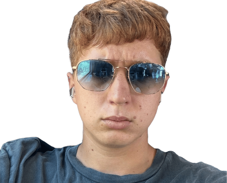 Young person with short strawberry blonde hair wearing gold-rimmed aviator sunglasses.