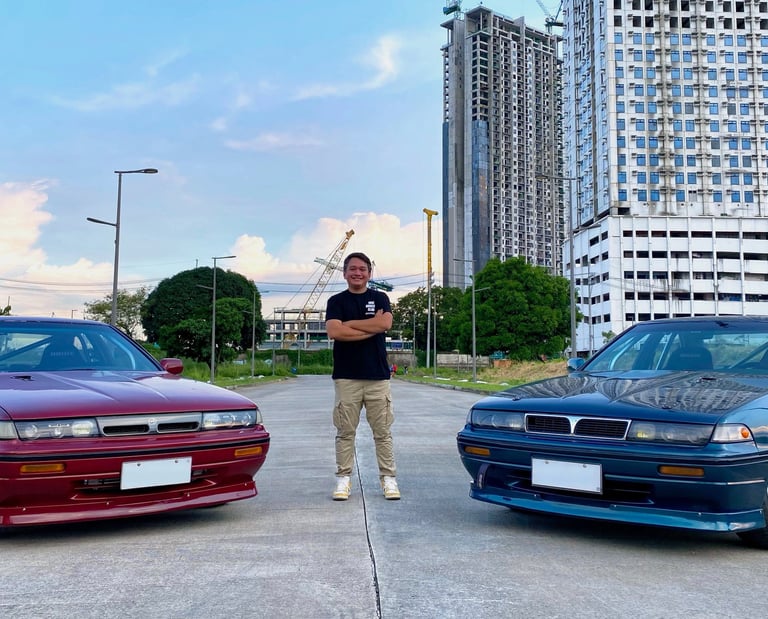 a man standing in the middle of two parked drift cars
