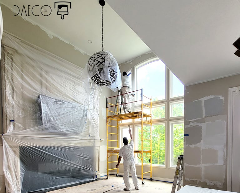 two painters in painter whites painting large living room