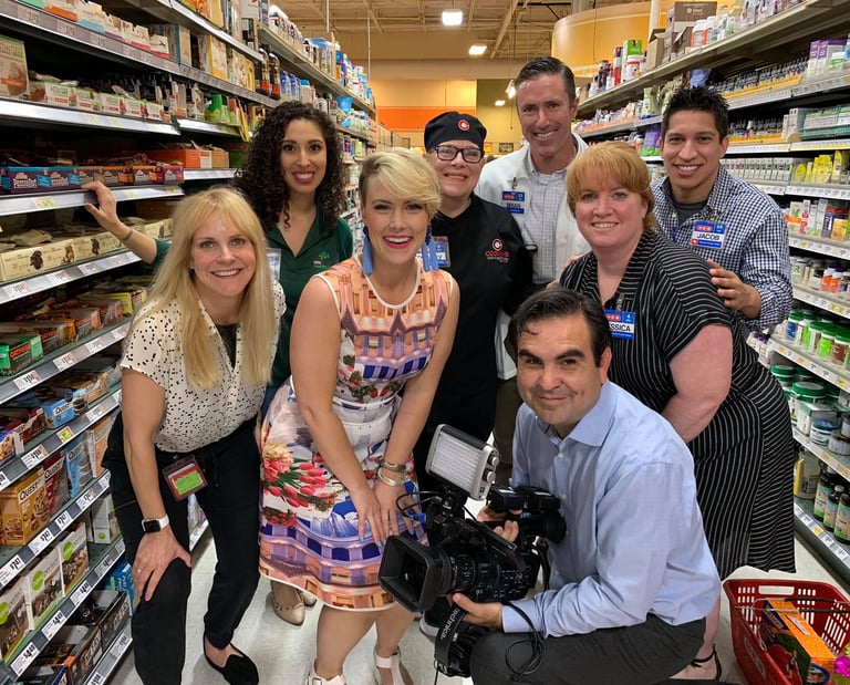 Francisco and Rosie Newbery at HEB, surrounded by talent, prepping to film a lively segment.