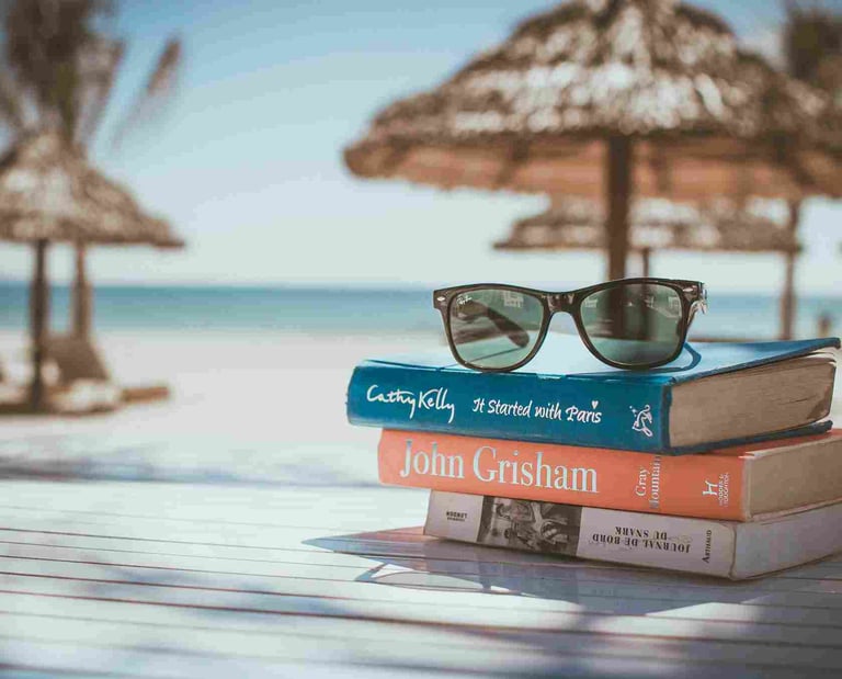 Sunglasses and books on a beach table