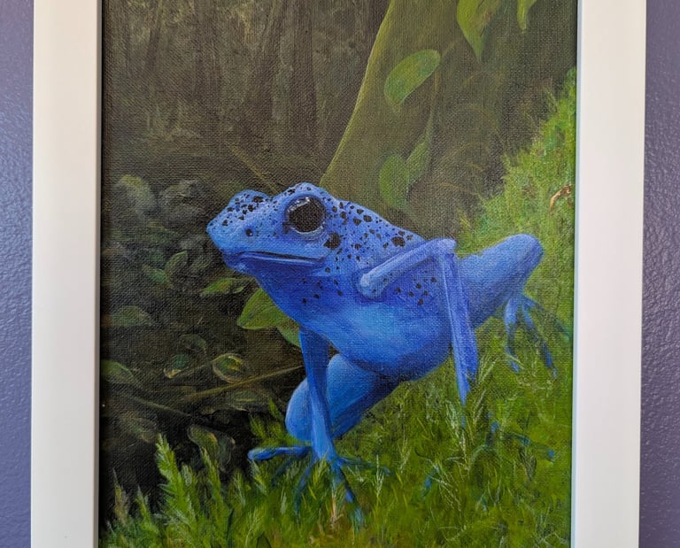 A realistically acrylic painted blue dart frog perched on green mosses.