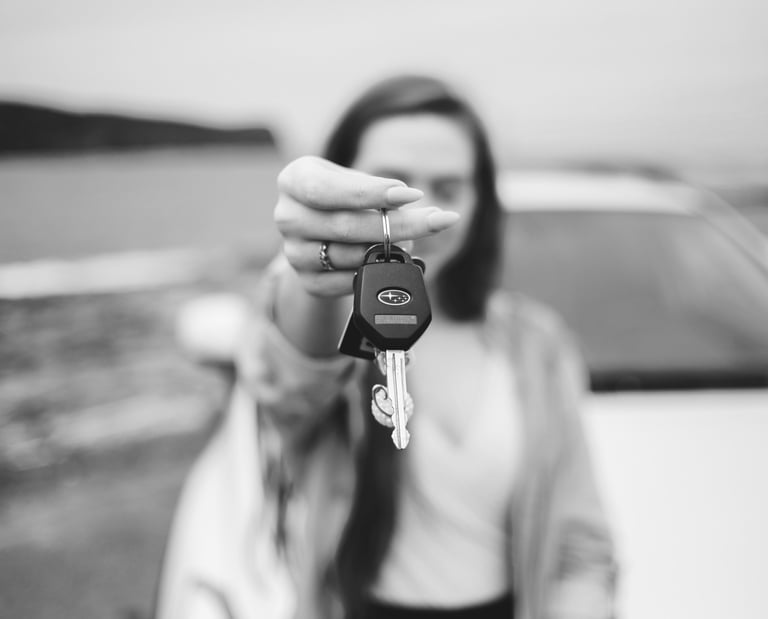 grayscale photo of a woman holding a keychain and a car keys