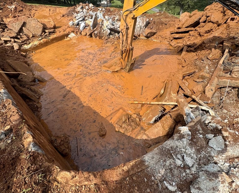 excavator digging out concrete pool