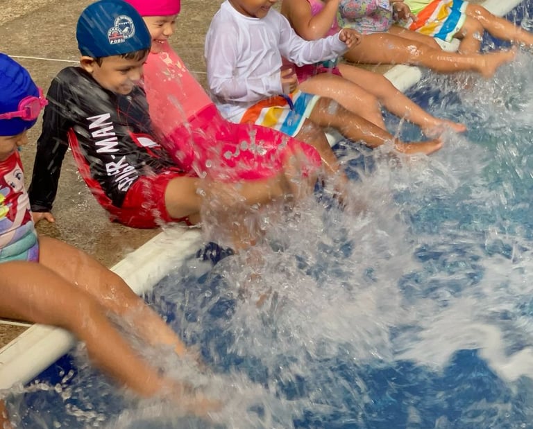 Niños pataleando el agua de una piscina en clase de natación en Aqua Fit Actividad de Ukelele Jardín Infantil