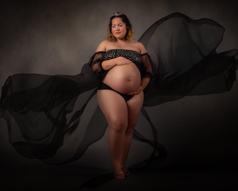 a pregnant woman in a black dress with a veil