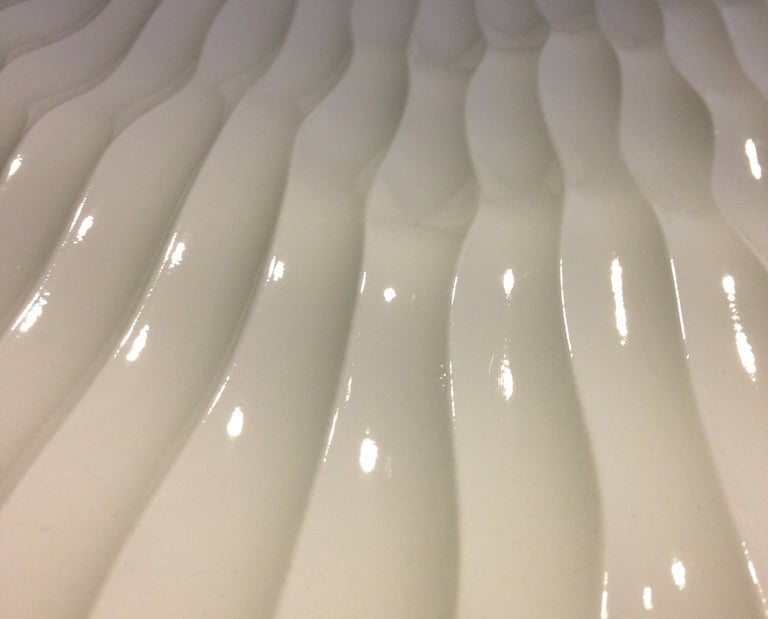 Heavy textured plastic surface with multiple paralel rounded bulging masses. 