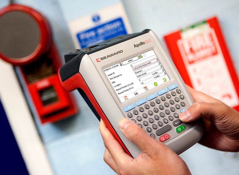 a person holding a portable appliance tester