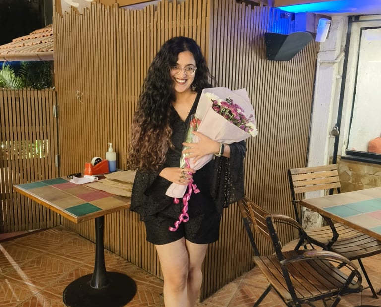 Riya, a human copywriter holding a bouquet of flowers