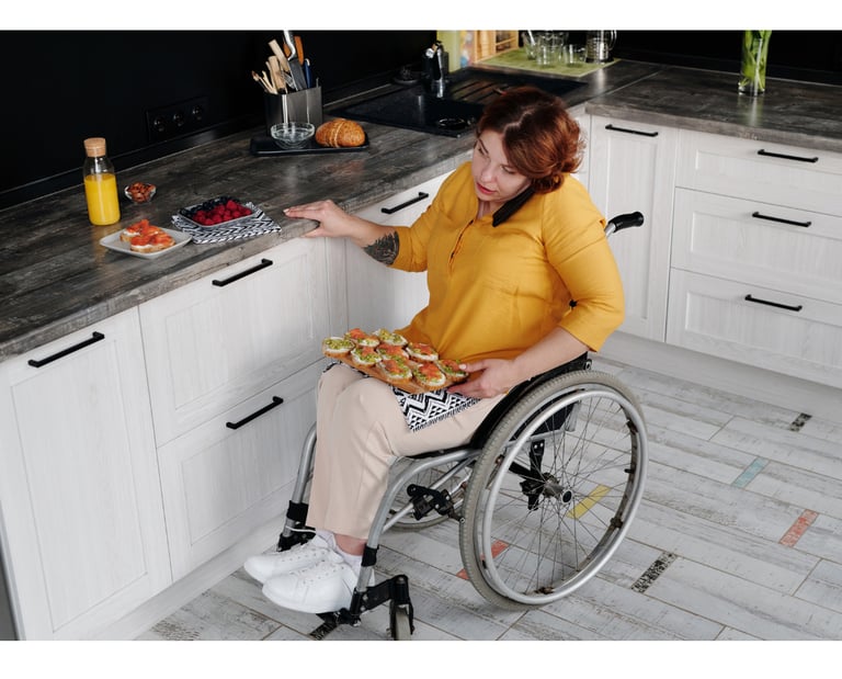 a woman in a wheelchair in her kitchen with a platter of food