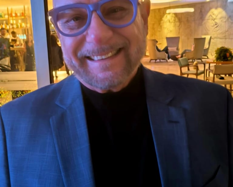 a man in a suit and glasses smiling