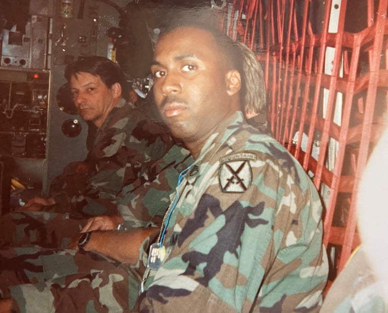 Lee A Jones in camouflage gear sitting in a military transport helicopter