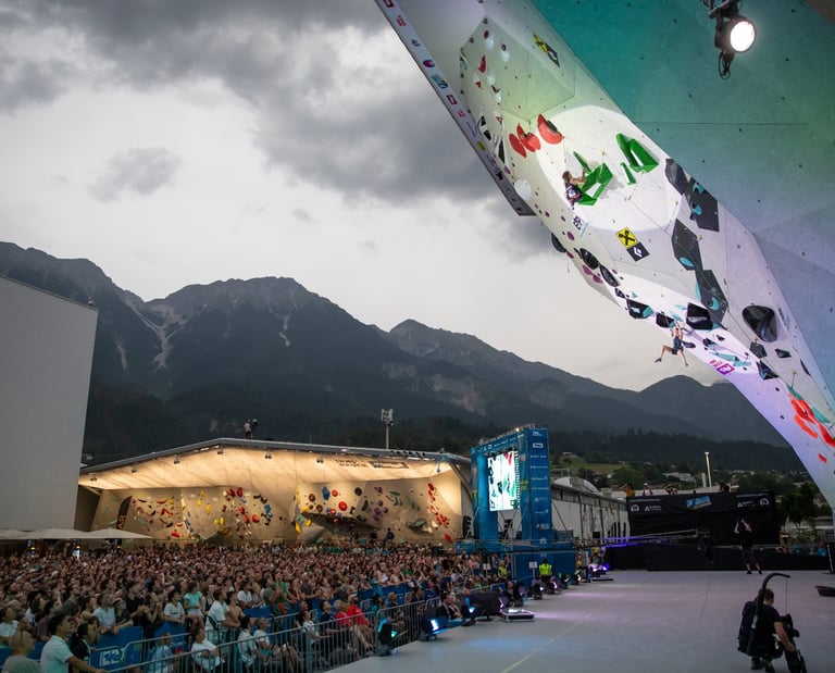 a climber on a climbing wall with a crowd of people watching