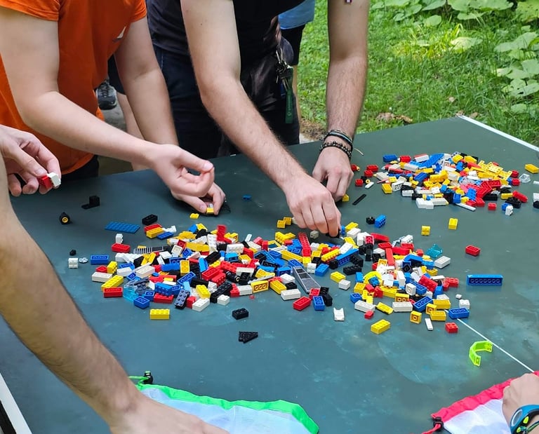 a group of people standing around a table with legos