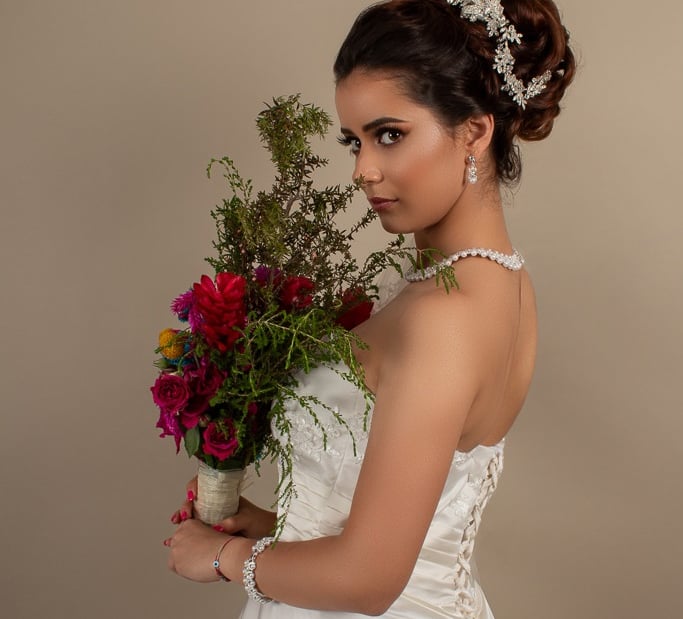 Retrato detallado de novia luciendo vestido de encaje en estudio.