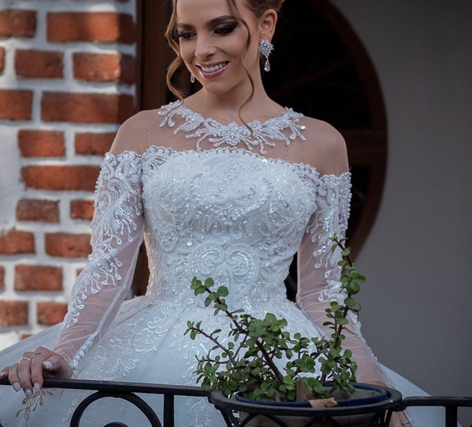 Retrato detallado de novia luciendo vestido de encaje en jardín de eventos.