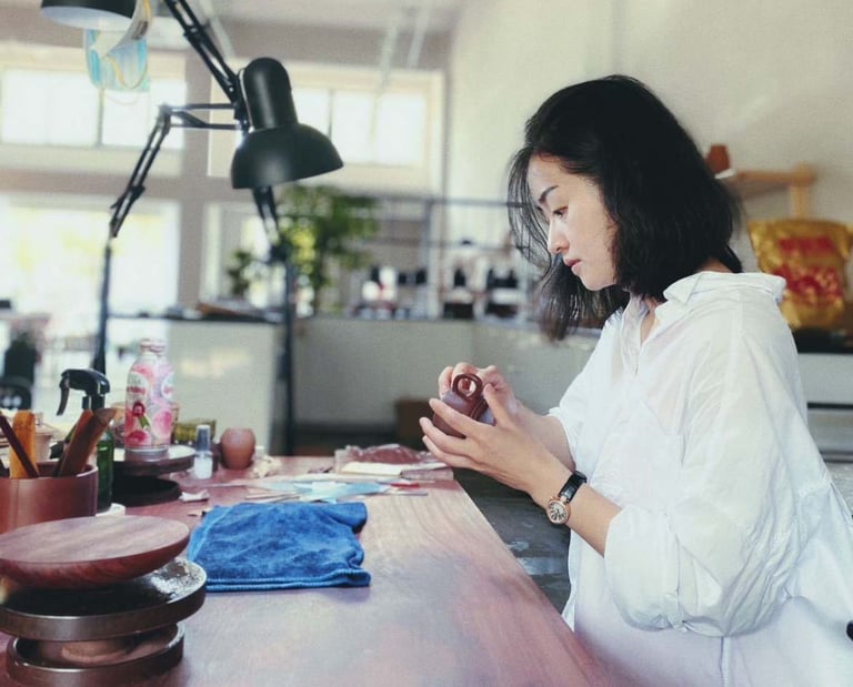 Artisan Kuai Yunhan examining a teapot