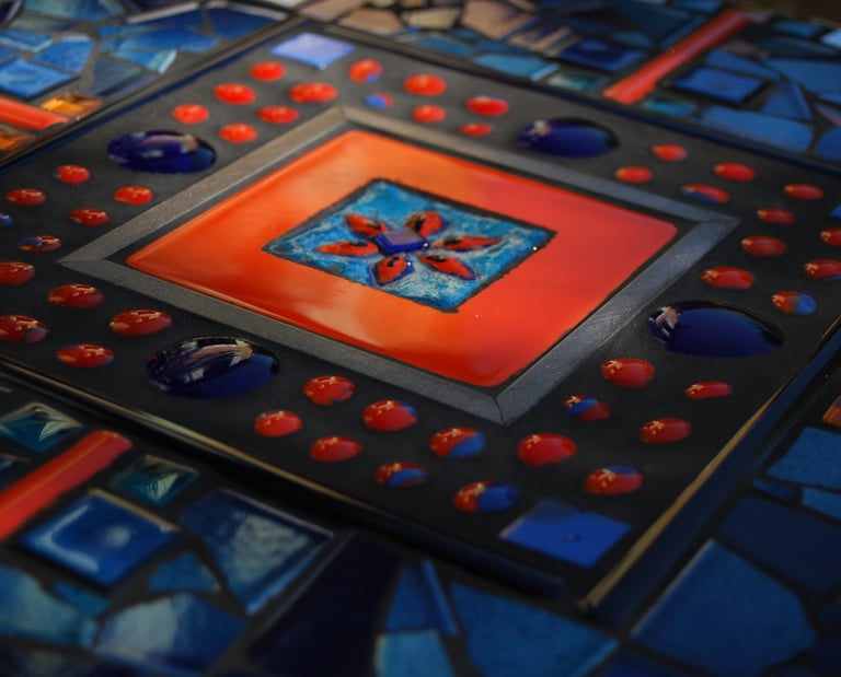 a table with a colorful glass tile and a red and blue tile
